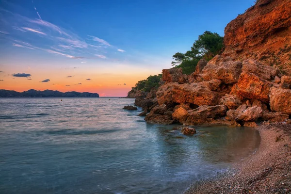 Bella vista sulla spiaggia rocciosa durante il tramonto . — Foto Stock