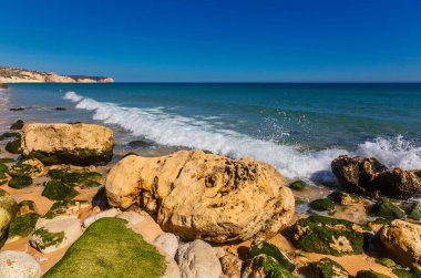 Atlantik kıyısında taşlar, kum ve temiz su. Salem plajı, Algarve, Portekiz