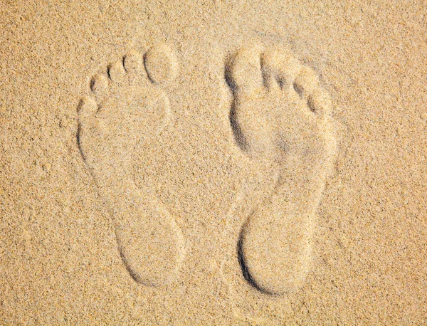 海滩沙滩上的两个脚印 免版税图库图片