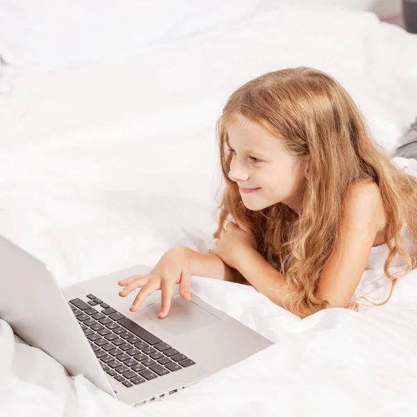 笔记本电脑的孩子 计算机在床上的女孩 宝宝玩 — 图库照片