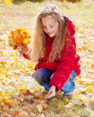 Sonbaharda kız. Parkta yaprağı olan çocuk