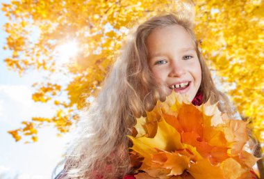 Sonbaharda kız. Parkta yaprağı olan çocuk