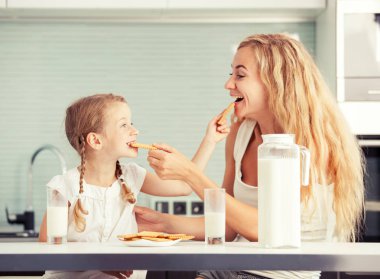 Çocuk ile anne süt içme. Mutlu aile evde yemek