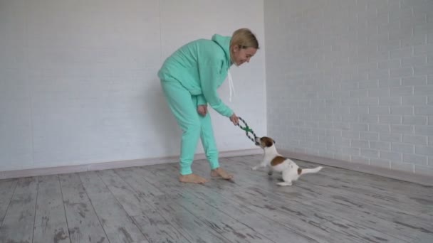 Kvinna leker med sin hund hemma — Stockvideo