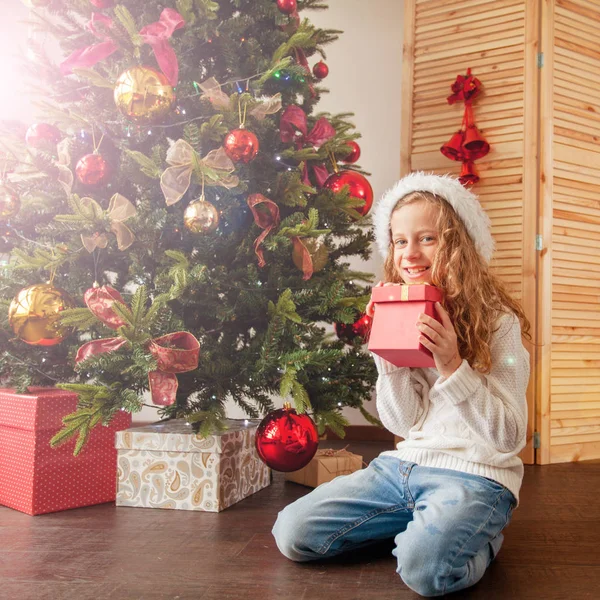 Barn med gåva nära julgran — Stockfoto