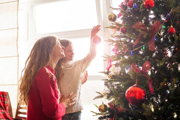 Anne ve kızı Noel ağacını süslüyor. — Stok fotoğraf