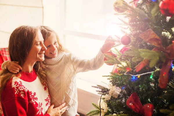 Mom and daughter decorate the Christmas tree