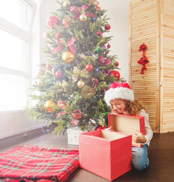 Barn med gåva nära julgran — Stockfoto