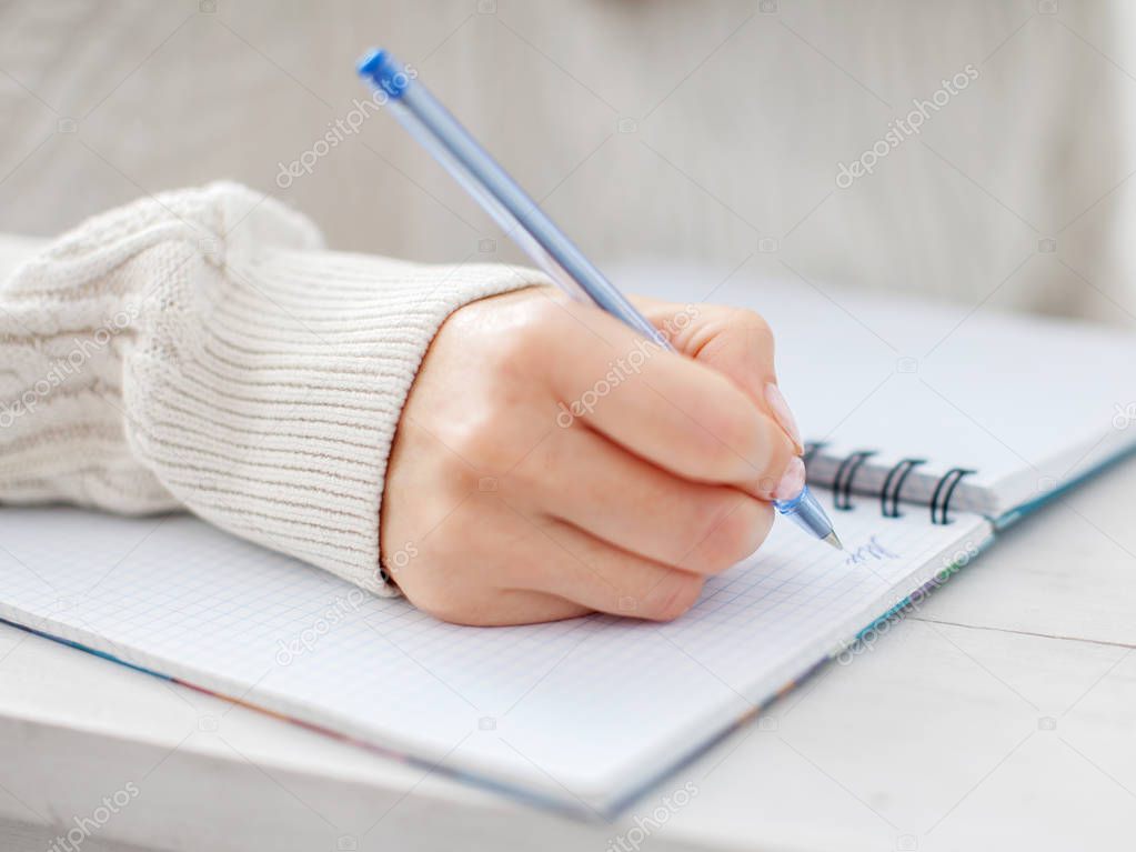 Woman writing pen in notebook