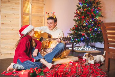 Gitar çalmak ve Noel şarkı bir baba ile kız tr