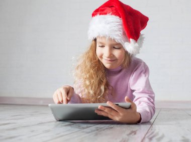 tablet ile Noel şapkalı çocuk