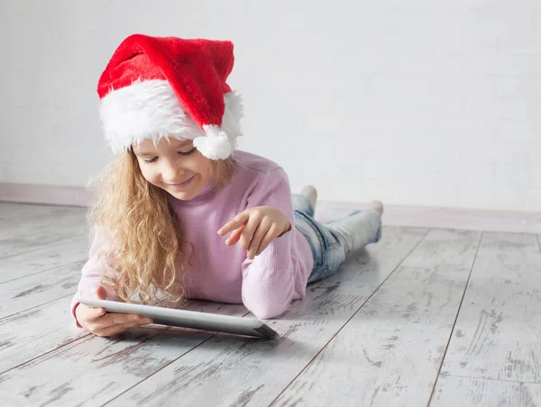 Niño en sombrero de Navidad con tableta —  Fotos de Stock