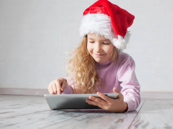 Enfant en chapeau de Noël avec tablette — Photo