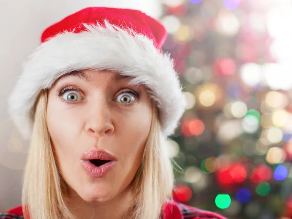 Happy surprised woman on Christmas tree background — Stock Photo, Image