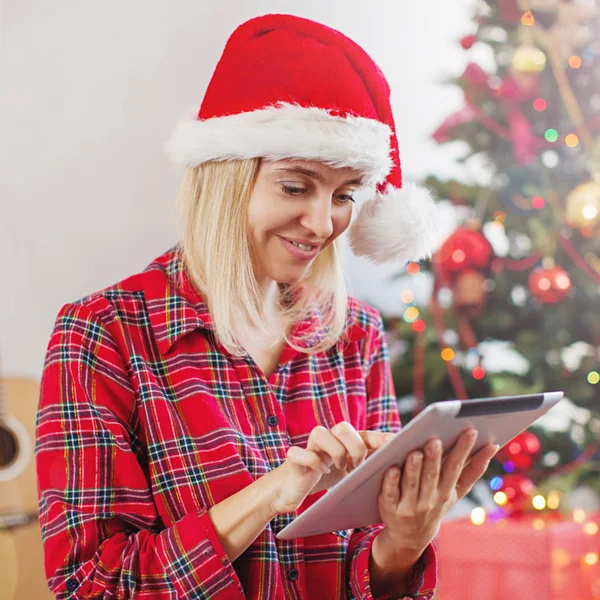 Mulher usando tablet na frente da árvore de natal — Fotografia de Stock