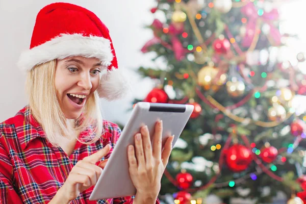 Mulher usando tablet na frente da árvore de natal — Fotografia de Stock