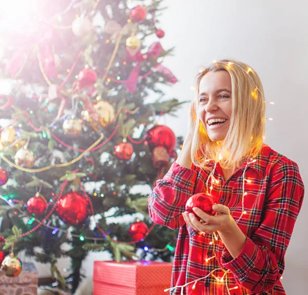 Mutlu kadın Noel ışıklarına sarılmış — Stok fotoğraf