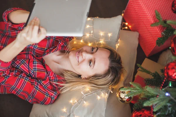 Mulher com tablet perto da árvore de natal — Fotografia de Stock