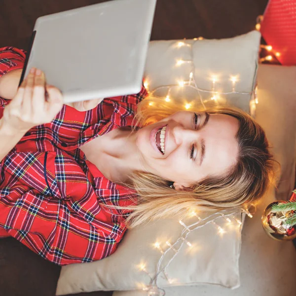 크리스마스 트리 근처에서 태블릿을 들고 있는 여자 — 스톡 사진