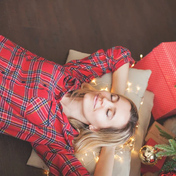 A nő hazudik és álmodik a karácsonyfa alatt — Stock Fotó