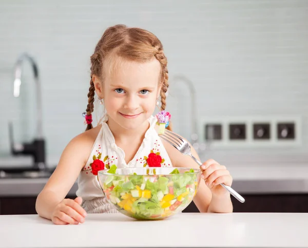 Liten flicka äter grönsakssallad — Stockfoto