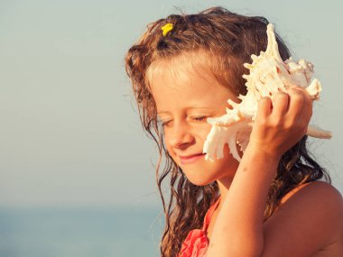 Çocuğu kabuk onun kulağına koy.