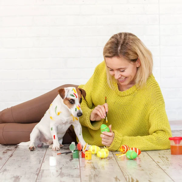 Frau und Hund malen Ostereier an — Stockfoto