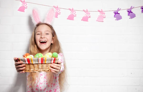 L'enfant tient un panier avec des œufs de Pâques — Photo