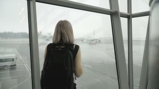 Una donna all'aeroporto che guarda l'aereo — Video Stock