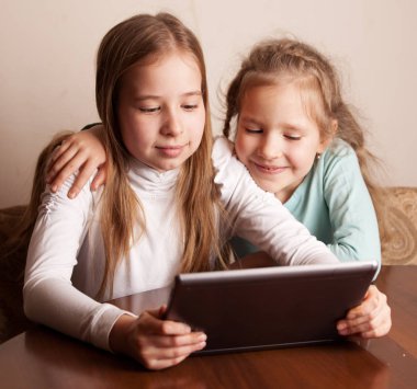 Tablet üzerinde oynayan çocuklar