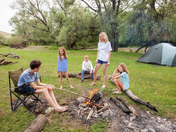 Tiener in het kamp bij het vuur — Stockfoto