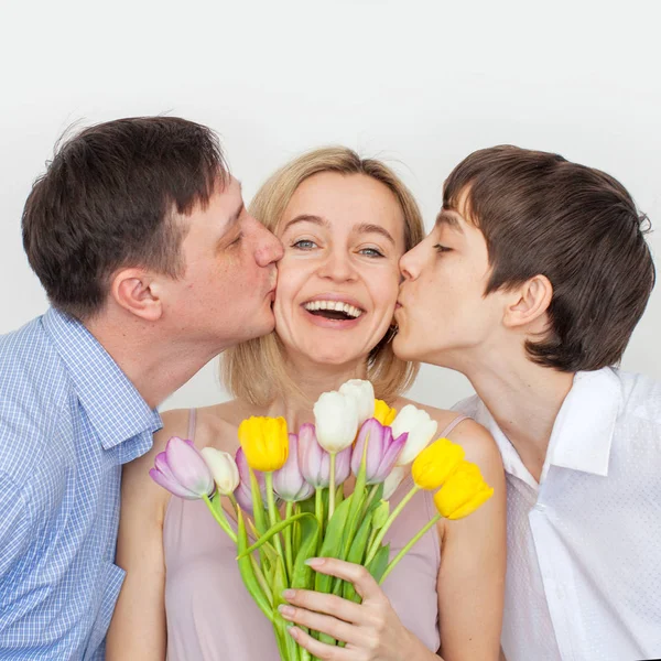 Mann und Sohn überreichen Frau einen Blumenstrauß — Stockfoto