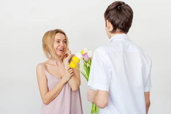 Filho dá a mãe um buquê de flores para o feriado — Fotografia de Stock