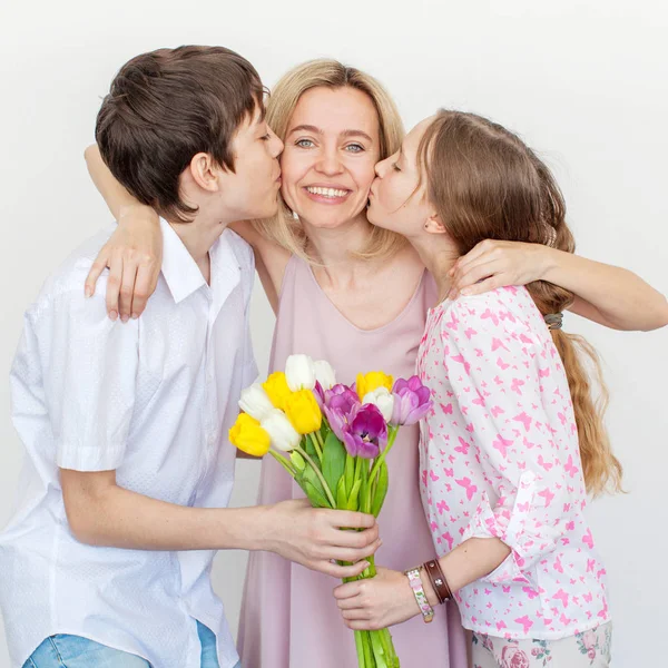 Daughter and son give mom flowers — Stock Photo, Image