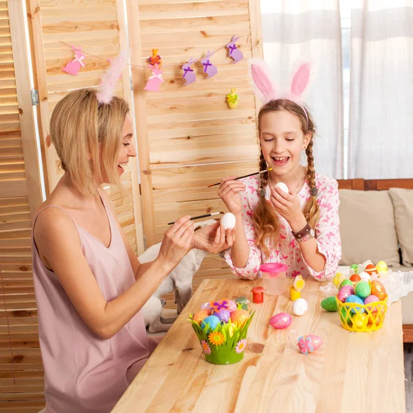 Heureuse femme adulte avec enfant peinture oeufs de Pâques — Photo