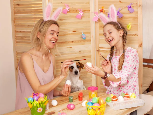 Mulher feliz com criança pintar ovos de Páscoa — Fotografia de Stock