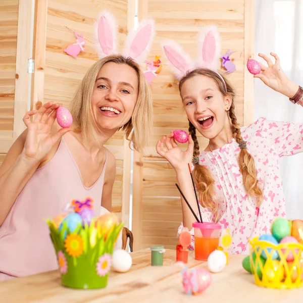 Femme heureuse avec enfant peinture oeufs de Pâques — Photo