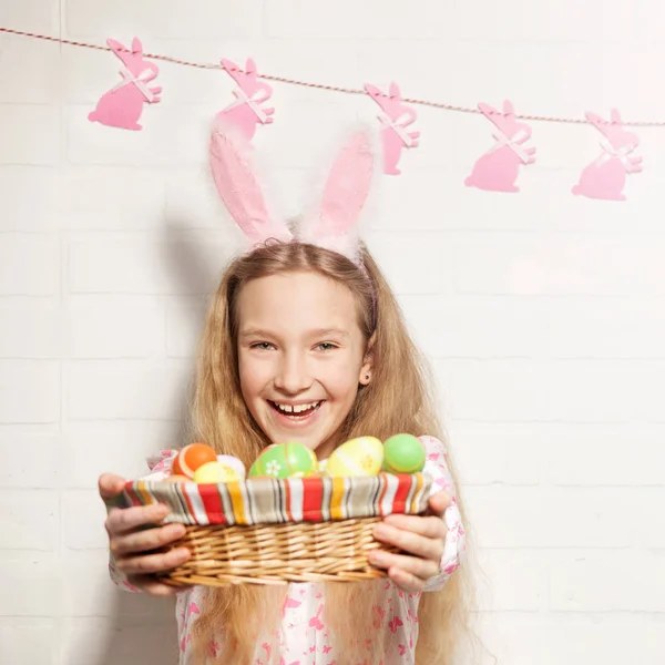 L'enfant tient un panier avec des œufs de Pâques — Photo