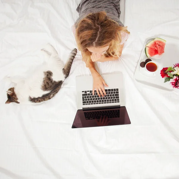 Jovem mulher com laptop na cama — Fotografia de Stock