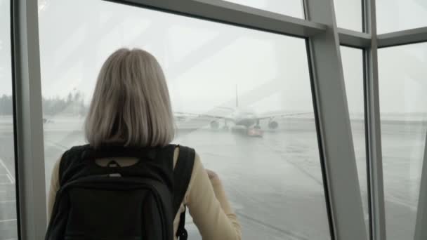 Mujer en el aeropuerto mirando el avión — Vídeo de stock