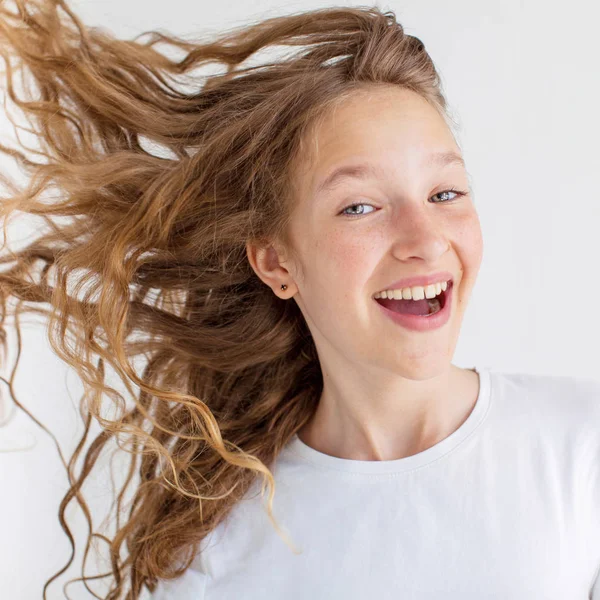 Portrét usmívající se mladá dívka dospívající s létající kudrnaté vlasy — Stock fotografie