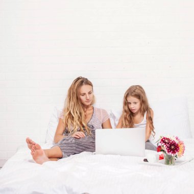 Aile ile laptop yatakta