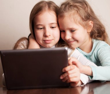 Tablet üzerinde oynayan çocuklar