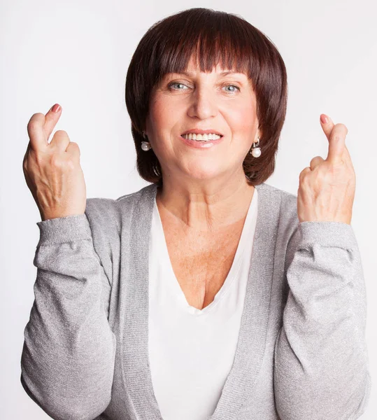 Mogen kvinna med korsade fingrar — Stockfoto