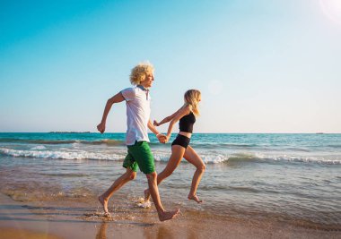 Eğleniyor kumsalda güneşli günde mutlu genç çift