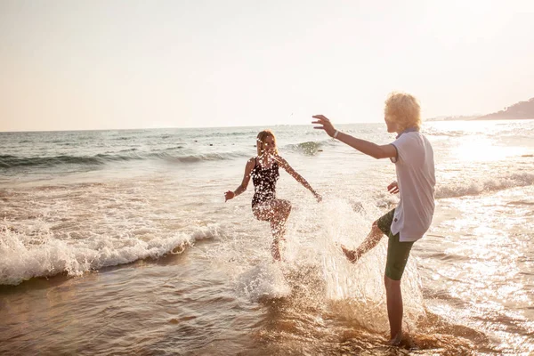 Gelukkige jonge paar plezier op het strand op een zonnige dag — Stockfoto