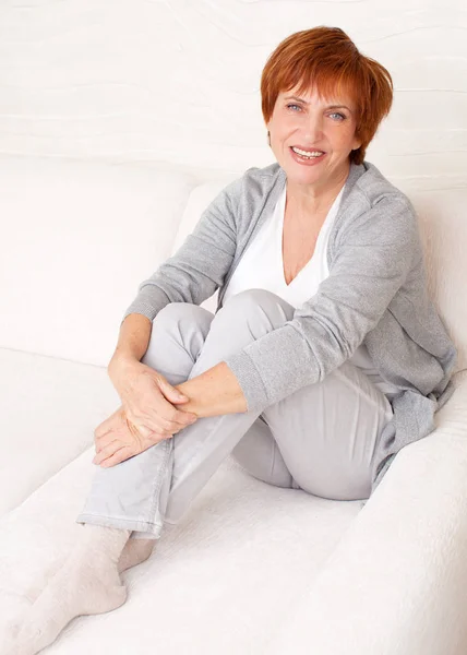 Happy mature woman on sofa — Stock Photo, Image