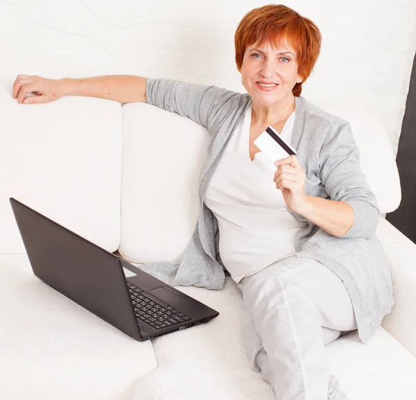 Starsza kobieta z karty kredytowej i laptopa — Zdjęcie stockowe