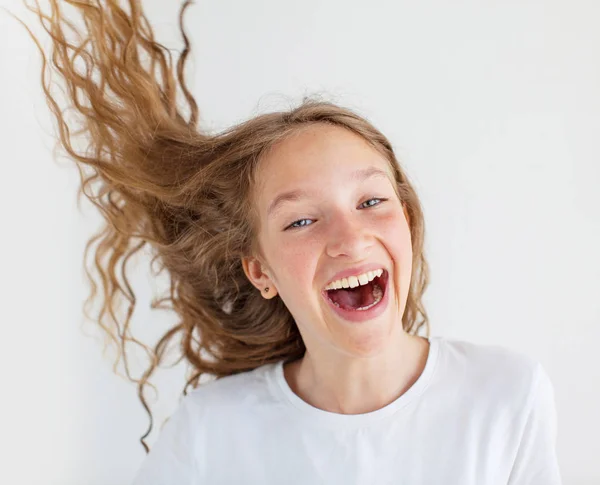 Portret lachende jonge meisje tiener met vliegende krullend haar — Stockfoto