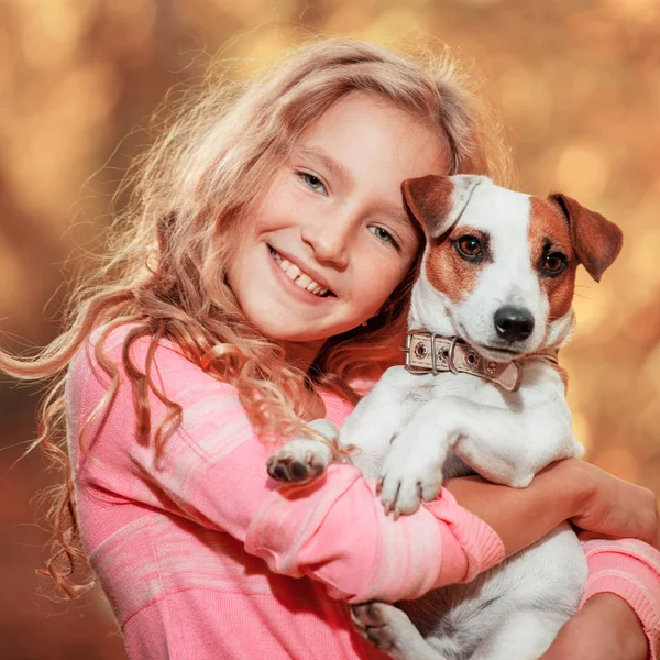 Ребенок с собакой осенью — стоковое фото